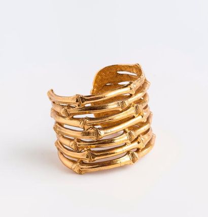 Yves Saint LAURENT 

Bracelet manchette en métal doré à motif ajouré façon bambou.

Tour...