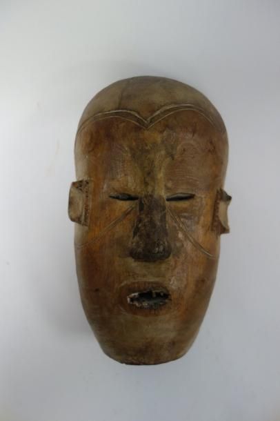AFRIQUE 

Masque en bois scarifié, aux oreilles stylisées, avec quelques dents et...
