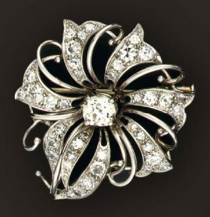 null Broche ajourée en platine et or gris simulant une fleur sertie en son centre...