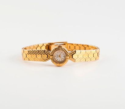 UNIVERSAL 

Montre bracelet de dame en or jaune (750). 

Lunette ronde crantée, cadran...