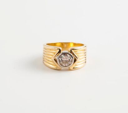 null Bague jonc strié en ors jaune et gris (750) ornée d'un diamant de taille brillant...