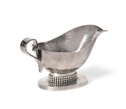 Jean DESPRES (1889-1980) Saucière en métal argenté martelé sur piédouche ovale, le...
