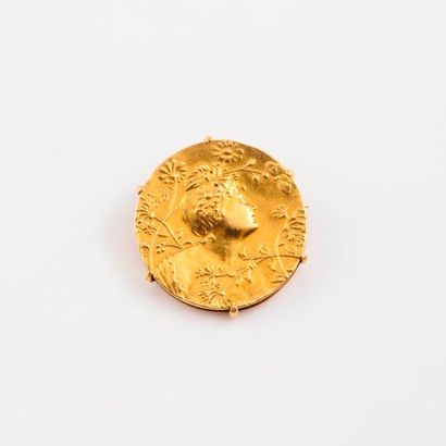null Broche en or jaune (750) ornée d'une médaille à décor d'une jeune femme entourée...