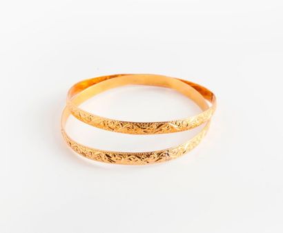 null Lot de deux bracelets joncs en or jaune (750) à décor ciselé de rinceaux. 

Poids...