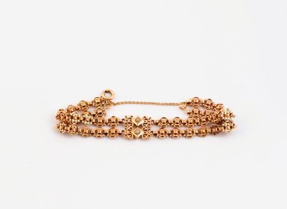 null Bracelet en or jaune (750) centré de volutes et semences de perles blanches,...