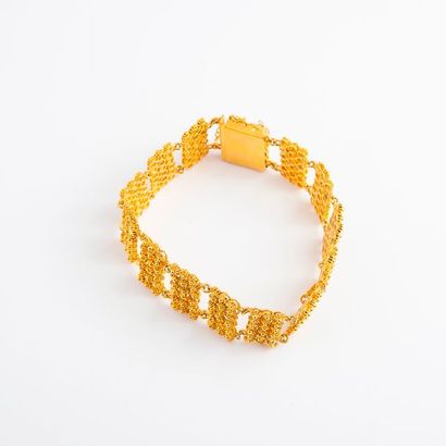 null Bracelet articulé en or jaune (750) à motif de fleurettes. 

Fermoir cliquet...