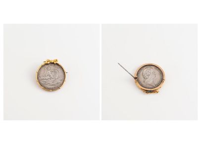  Broche circulaire en or jaune (750) sommée d'un noeud de ruban et retenant un jeton...