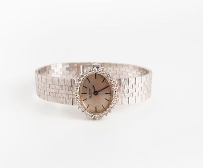 ALEX HUNING 
Montre bracelet de dame en or gris (750). 
Boîtier ovale cerclé de petits...