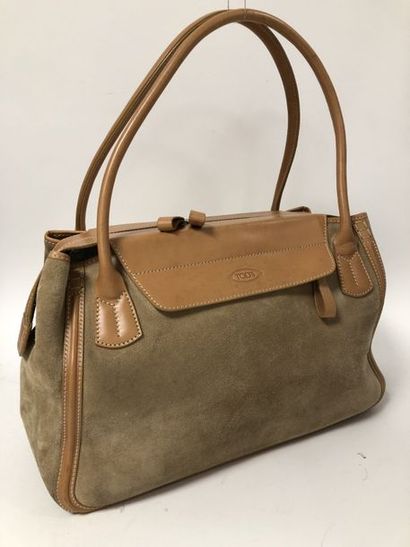 TOD’S 
Sac en daim et cuir fauve à deux anses porté épaule ou main.
Surpiqures sellier.
Fermeture...