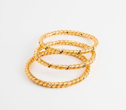 null Trois bracelets joncs en or jaune (750) torsadé et rainuré ornés pour l'un de...