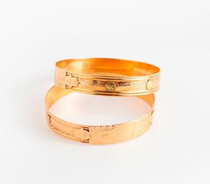 null Deux bracelets jonc rigides en or de deux tons (750) à décor ciselé de motifs...