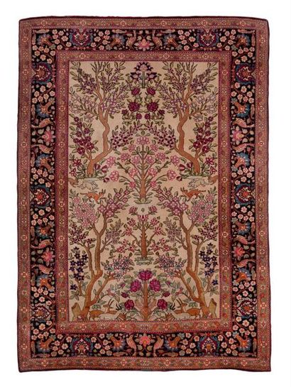 IRAN, XXème siècle 

Tapis en laine polychrome à décor d'arbres et chargé de fleurs...