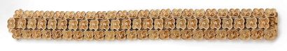 MICHÈLE MORGAN Bracelet articulé en or deux tons (750) formé de trois lignes de fleurettes.
Signé.
Fermoir...