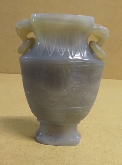 CHINE, XXème siècle 
Petit vase méplat en calcédoine à décor de masques de Taotie,...