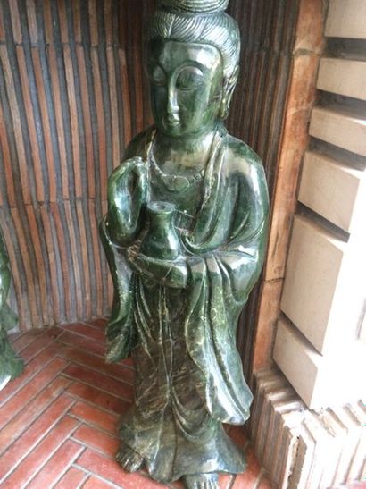 CHINE, XXème siècle 
Guanyin tenant un flacon en pierre vert épinard.
H. : 63 cm...