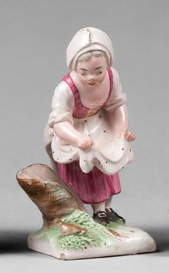 NIDERVILLER 
Statuette en faïence représentant une jeune paysanne tenant son tablier,...