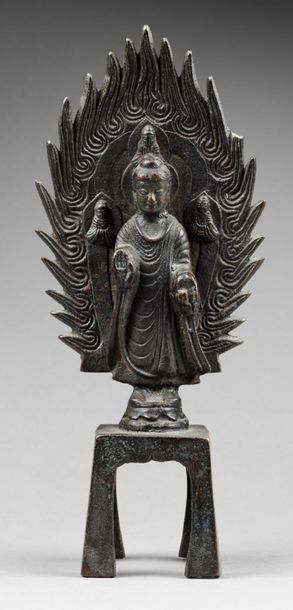 CHINE - XIXe siècle 
Statuette de bouddha en bronze à patine brune debout sur un...