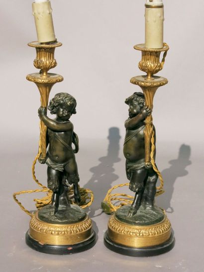 null 
*PAIRE DE FLAMBEAUX en bronze patiné et doré représentant




deux petits faunes.




Contre...