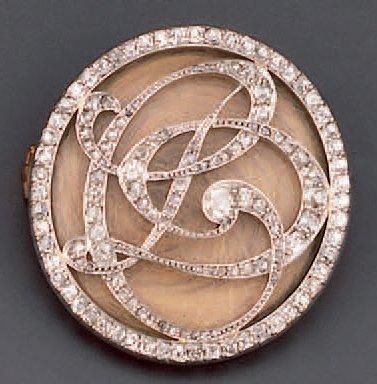 null Broche ronde en or et platine décorée en ajouré d'un monogramme serti de diamants...