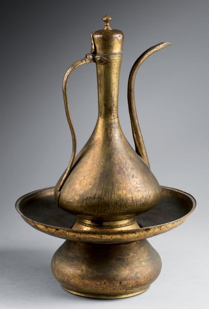 null Ewer and its gilded copper basin (tombak). 
 The ewer with a pear-shaped body...