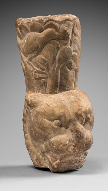 null Trapezophore fragment representing a feline head surmounted by a vegetal element.
Marble....