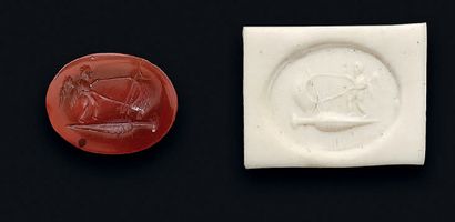null A carnelian oval intaglio engraved with an Eros sailing on an amphora topped...