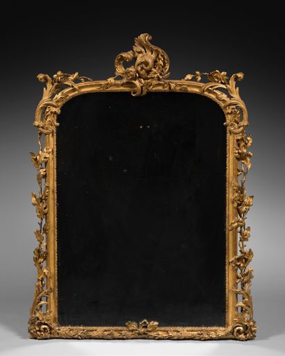 null A carved and gilded wood mirror, decorated with oak branches, leafy clasps and...