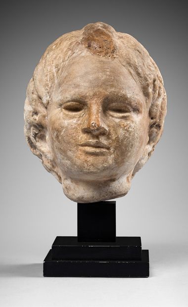 null Head representing a child (Eros ?) whose hair is gathered in a braid on the...