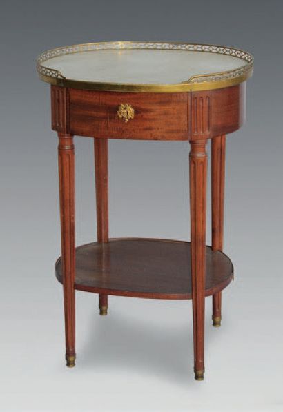 null Mahogany oval table, opening to a drawer and resting on tapered legs with flutes;...