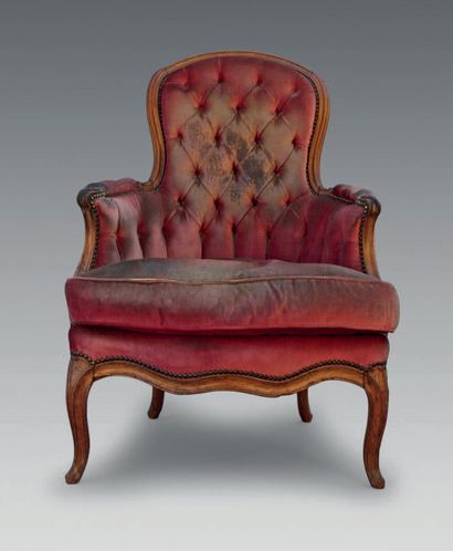 null A moulded beechwood armchair with a rounded cabriolet back resting on curved...