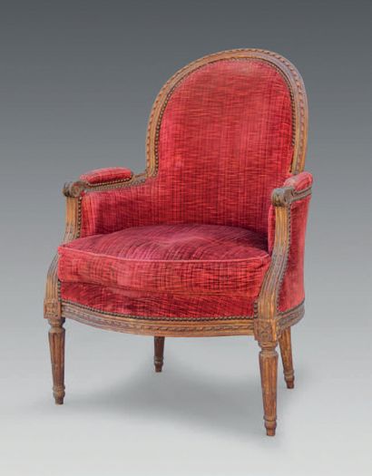 null A moulded and carved beechwood armchair with a rounded cabriolet backrest, decorated...