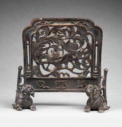 CHINE-XIXe siècle Un écran en bronze à patine brune soutenu par deux chimères, l'écran...