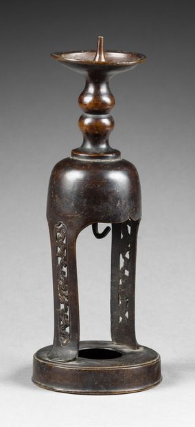 CHINE-XIXe siècle Pique-cierge en bronze à patine brune, les côtés ajourés de frises...