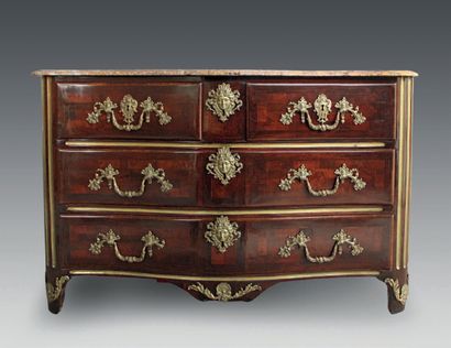 null A rosewood chest of drawers, the curved front opening to four drawers on three...