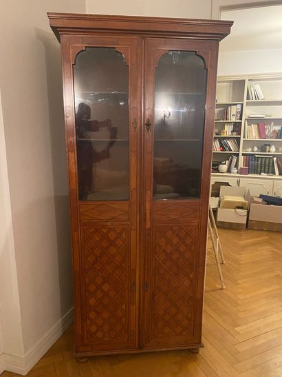 null Narrow bookcase in light wood and marquetry opening with two doors partly glazed....
