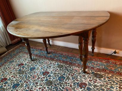 null Table with two flaps in walnut resting on six bulbous feet with casters. Rustic...