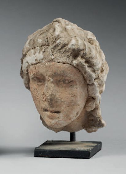 null Head with wavy hair, adorned with earrings.
Stucco and pigments. Limestone deposit....