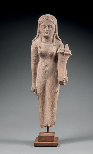 null Statuette representing a female deity dressed in a spindle dress in the attitude...
