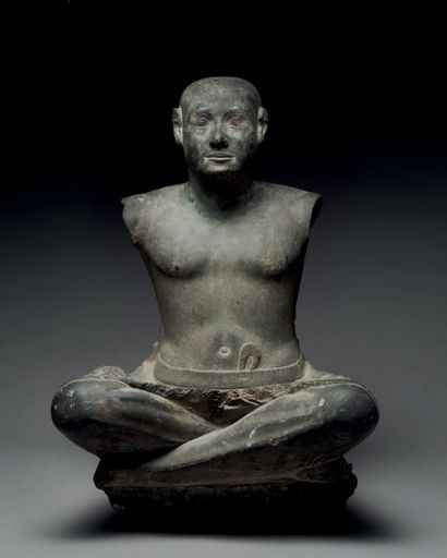 null Statue representing a character with a bald head sitting cross-legged.
Black...