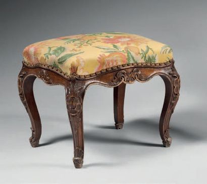 null Walnut stool decorated with cartouches and foliage, resting on cambered legs.
Italy,...