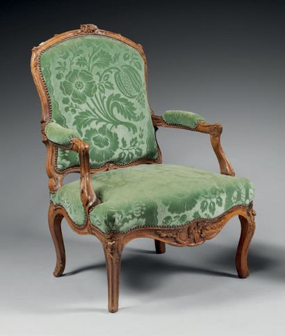 null Armchair in molded and carved walnut with flat back and decoration of leafy...