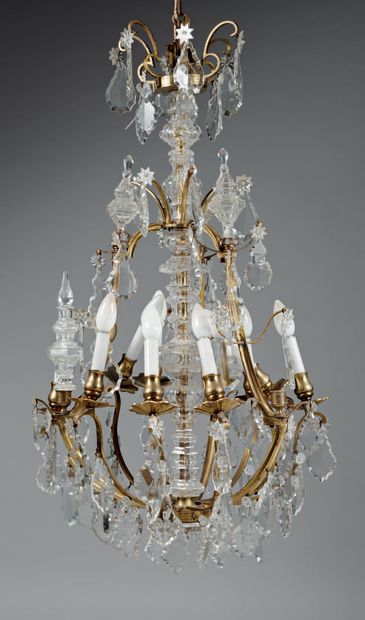 null Lustre en bronze doré et verre taillé à neuf lumières et décor de pendeloques...