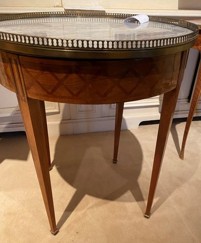 null Circular table in cross marquetry, opening to a drawer and resting on sheath...