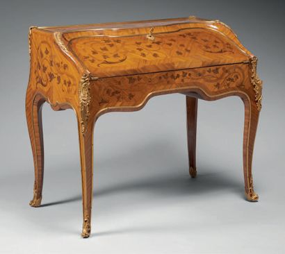 null A sloping secretary in buttwood marquetry, opening to a flap revealing six drawers...
