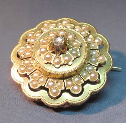 null Broche rosace en or jaunes sertie de demi perles et centrée d'un diamant taillé...