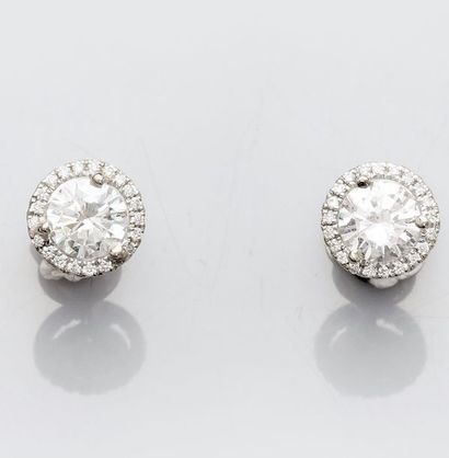   Paire de boucles d'oreilles en or gris 750°/00 (18K), chacune est sertie d'un diamant...