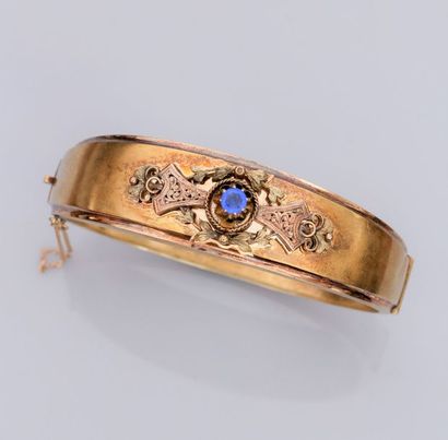   Bracelet rigide ovale en or de couleurs 750°/00 (18K), à décor repercé de rinceaux...