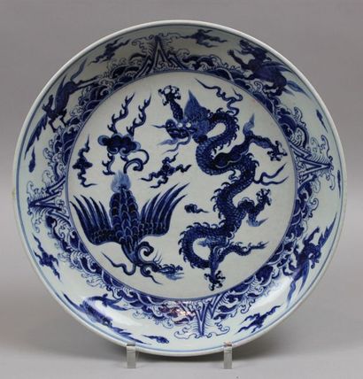 null Chine. Grand plat rond en porcelaine à décor blanc bleu figurant un dragon et...