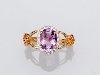 null Two-tone 375°/00 gold ring set with an oval amethyst surrounded by small diamonds...