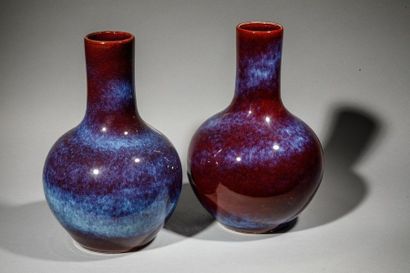 null Paire de vases au long col en porcelaine bleu sur fond aubergine. Chine, XXème...